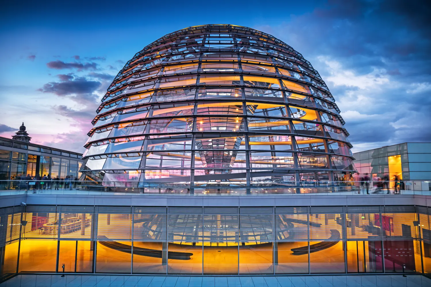 Die Dachterrasse und die beleuchtete Glaskuppel des Reichstagsgebäudes am Abend